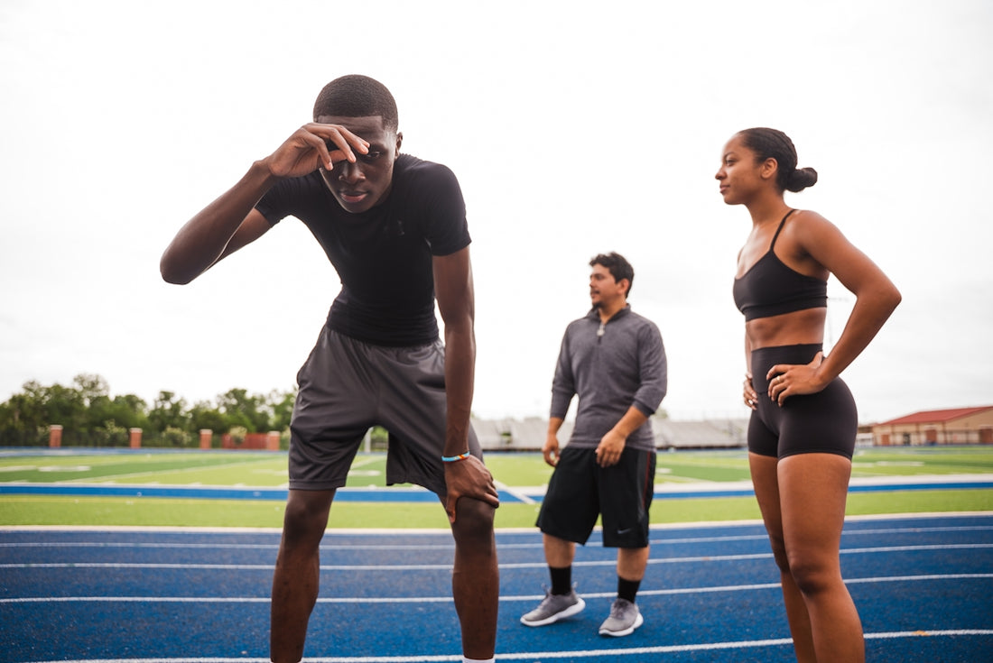 Athletes resting on a track after training.